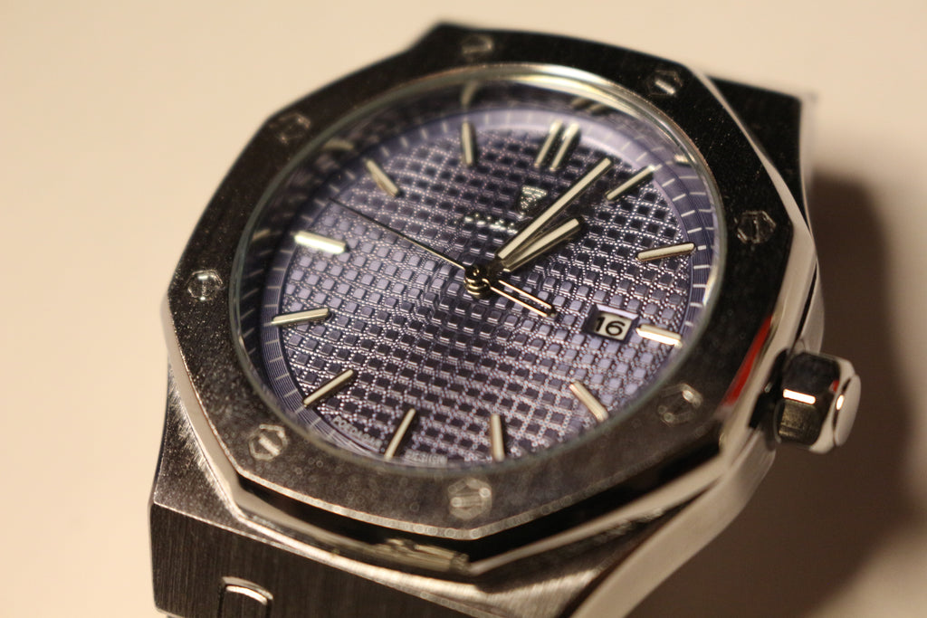 Close-up of the Bartlett 1954 Serov blue textured dial, octagonal bezel with exposed screws and date window