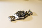 Bartlett 1954 Arvel lying on its side, showing the brushed steel bracelet and blue dial
