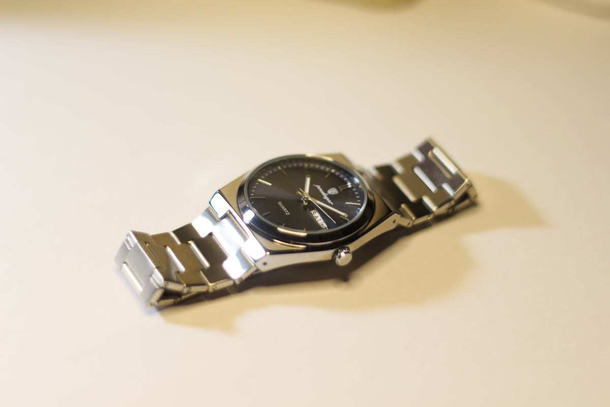 Bartlett 1954 Arvel lying on its side, showing the brushed steel bracelet and blue dial