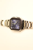 Bartlett 1954 Novella standing upright, square case with a blue lined dial and day-date