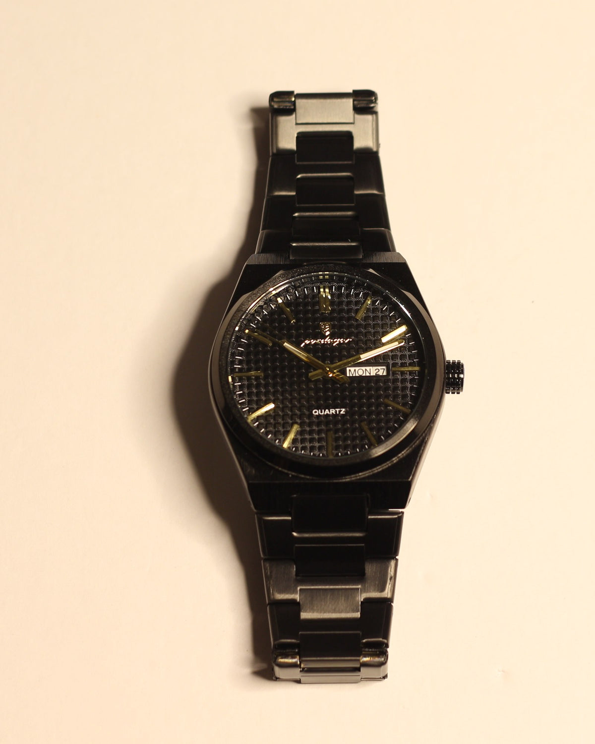 Bartlett 1954 Orin, black case and bracelet with a black textured dial and gold hands, front view
