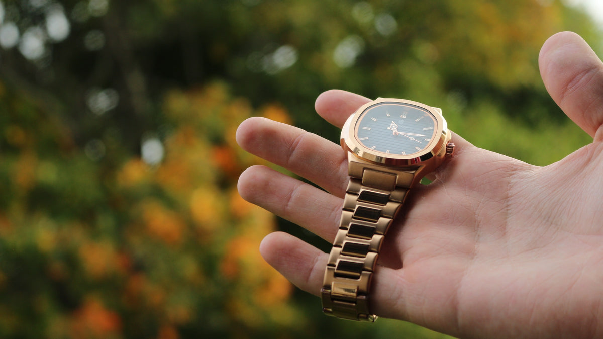 Bartlett 1954 Rivant in rose gold resting in an open hand, angled view of the case